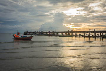 Fototapeta premium Fishing boats in the sea and a beautiful sky while the sunset, at harbour bridge, Chao Lao Beach, Chanthaburi, Thailand.