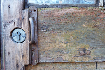 Fragment of an old door with the handle and the lock.