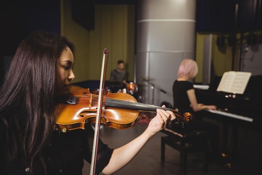 Two female students playing violin and piano