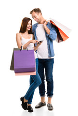 Couple with shopping bags and cellphone, on white