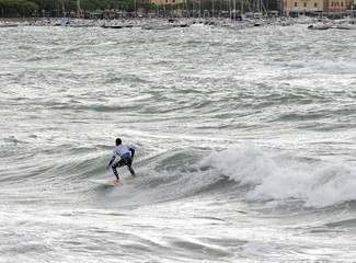 Naklejka premium a surfer surf a wave in italy