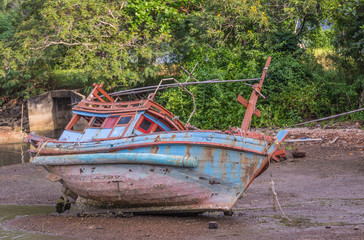 Old fishing boat dilapidated on shore at Aoh  Khung  Kraben, Chanthaburi, Thailand.
