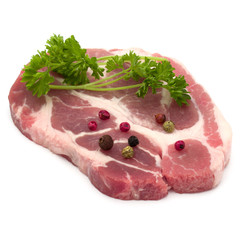 Raw pork neck chop meat with parsley herb leaves and peppercorn