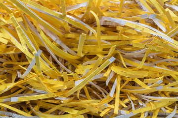 Yellow shredded paper from paper shredder.