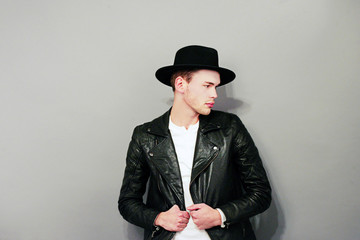 Cute boy in black hat posing in a studio