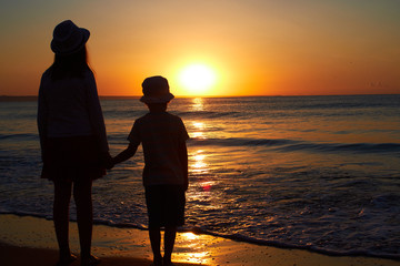 sister and brother sunset at the sea