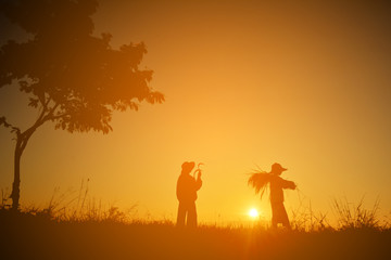 Silhouette of children holding rice on field in harvest season,Happy farmer at sky sunrise in the morning