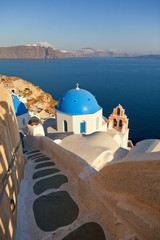 Red belled church in Oia, Santorini at daylight. Stairs way on f