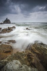 beautiful beach with rock hitting by waves. soft focus due to lo