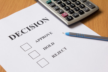 Decision paper (approve, hold, reject) with pen, calculator