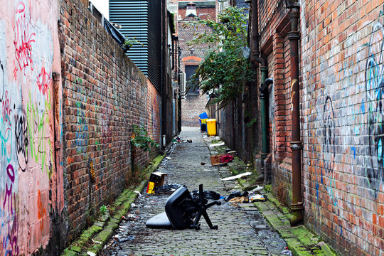 Fototapeta Wheelie bins in a garbage strewn alleyway