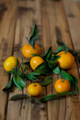 Mandarins fruit with leaves on wooden background