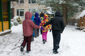 Fototapeta na wymiar Children on walk in kindergarten in the winter.