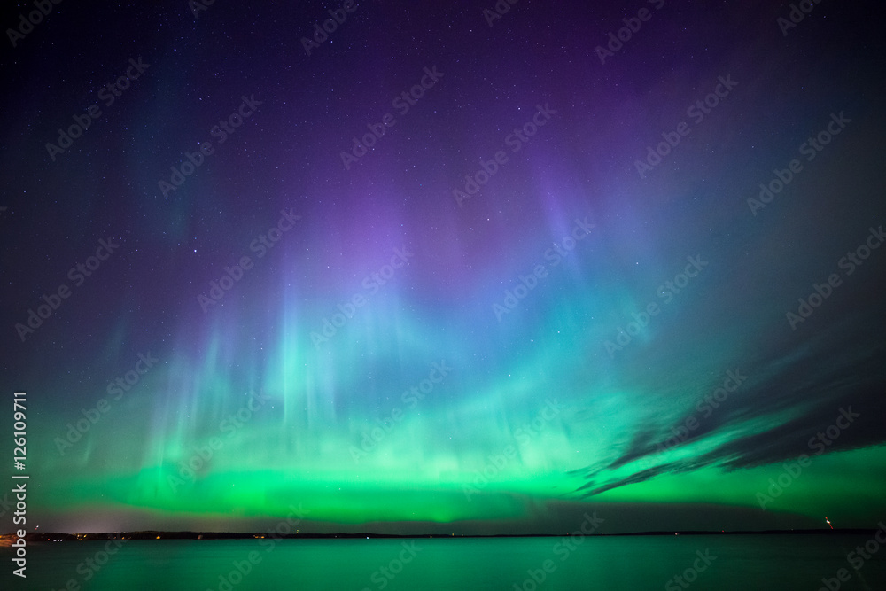 Wall mural northern lights over lake in finland