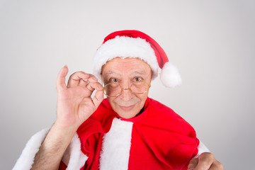 Senior in Weihnachtsmann Kostüm mit goldener Brille