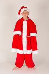 kleiner Junge mit viel zu großem Weihnachtsmann Kostüm hat Spaß (mit Mütze)