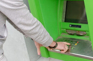 Young man is using cash machine