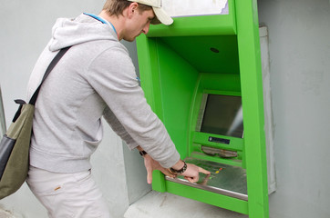 Young man is using cash machine