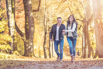 Fototapeta premium Verliebtes Pächen läuft freudestrahlend durch den Herbstwald