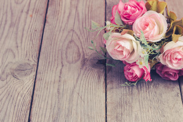 Fake roses,Plastic roses on wood. Vintage roses in pink