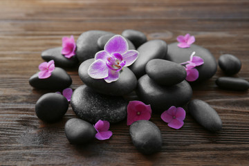 Fototapeta na wymiar Spa stones with orchid and hydrangea on wooden background