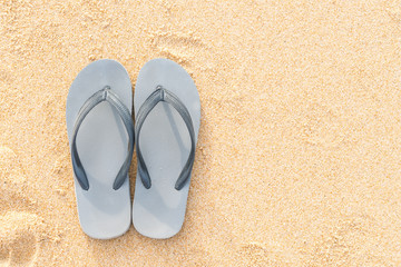 Fototapeta na wymiar sandals on the sandy sea coast