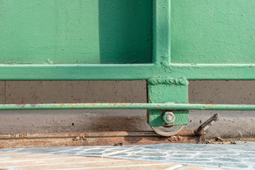 steel wheels of slide green door