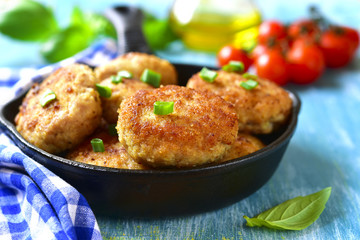 Chicken cutlets in a skillet.