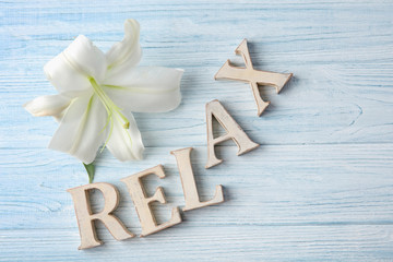 Fototapeta na wymiar Word RELAX made of letters with flower on wooden background