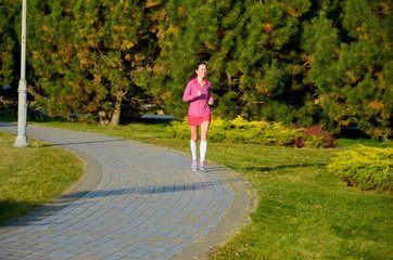 Fototapeta premium Woman running in autumn park, beautiful girl runner jogging outdoors, training for marathon, exercising and fitness concept 