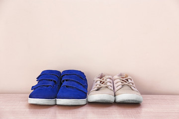 Different baby shoes on light wall background