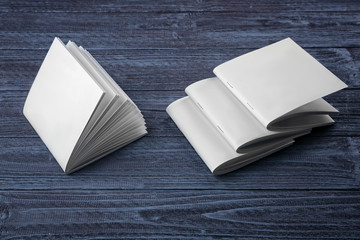 Blank brochures on dark wooden background