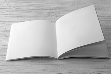 Blank open brochure on light wooden background