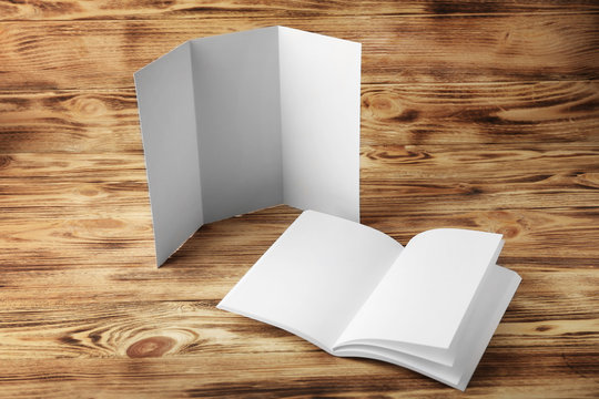 Blank brochure and booklet on wooden background