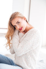 Fototapeta premium Woman wearing sweater and red lipstick looking at camera