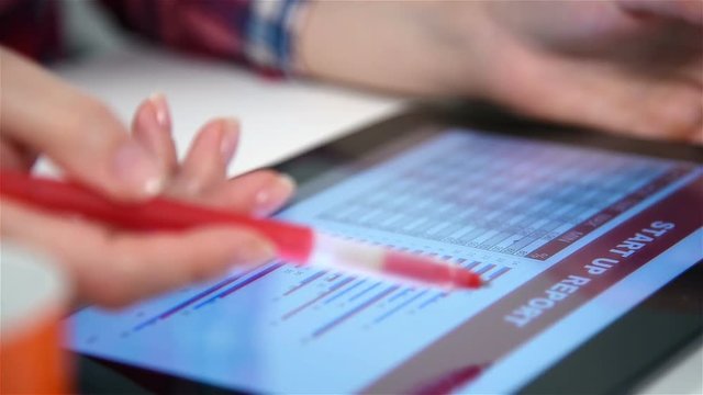 Hand With Pen Using Digital Tablet With Stock Chart Report. Cloae Up
