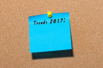 Trends 2017 written on blue sticker pinned at notice board. New year business and fashion innovation