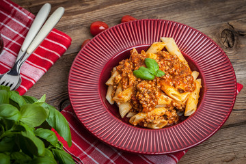 Penne a bolognese on white plate.