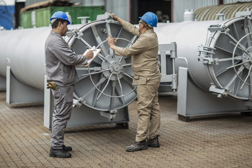 Workers in factory checking horizontal retort