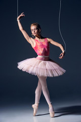ballet dancer as puppet dancing over gray background