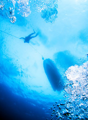 Scuba Diver Silhouette and Air Bubbles under Boat.