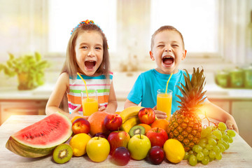 Kids with fruits and fresh juice in kitchen, healthy eating