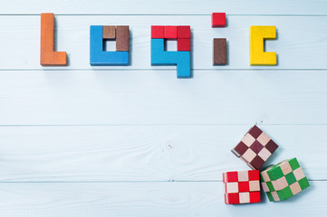 Fototapeta na wymiar The word of logic of multi colored wooden blocks on a wooden bac