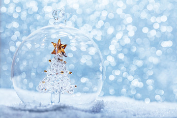 Christmas glass ball with crystal tree inside in snow