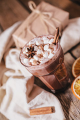 Cocoa or latte or hot chocolate with marshmallow and flavored with cinnamon. On a brown wooden background. Christmas present. Christmas concept. Christmas holiday.