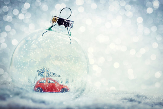 Christmas glass ball in snow with miniature winter world inside