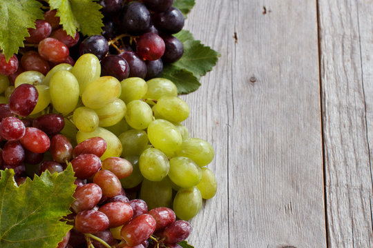 Three types of grapes on a wooden Background