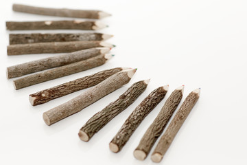 Color wooden pencils is on the light background. Unusual pencils for drawing made how logs.
