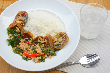 Rice topped with stir-fried preserved egg slice and basil.
