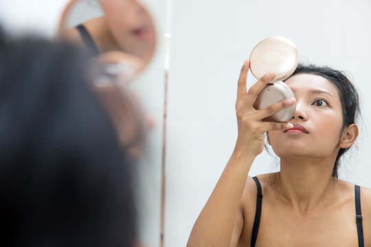 Woman In The Mirror Is Looking Into A Handheld Mirror